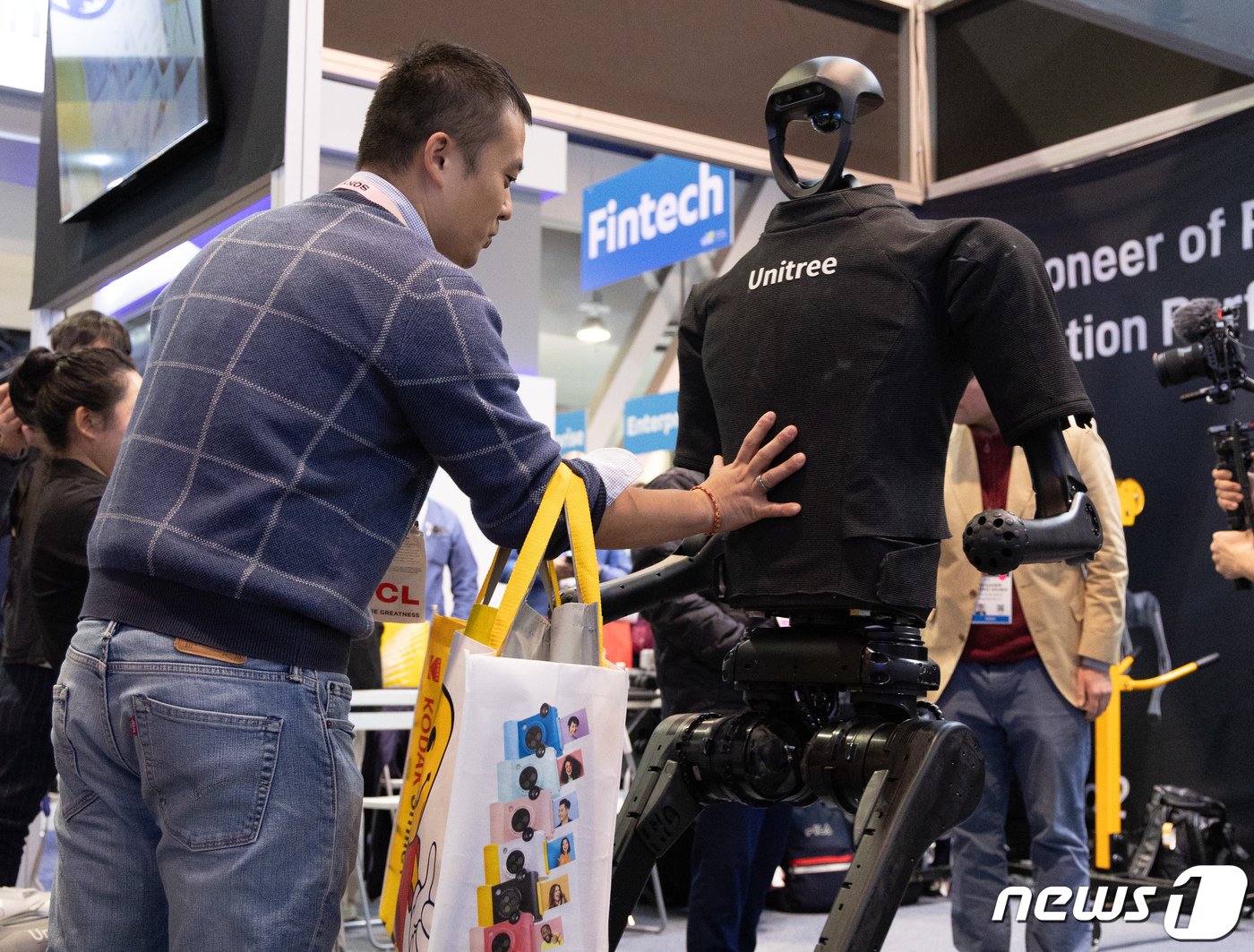 본문 이미지 - 세계 최대 가전·IT(정보기술) 전시회 'CES 2024' 개막 이틀째인 10일(현지시간) 미국 네바다주 라스베이거스 컨벤션센터(LVCC)에 마련된 유니트리 전시관에서 관람객이 AI를 적용한 4족로봇을 밀어보고 있다. 2024.1.11/뉴스1 ⓒ News1 이재명 기자