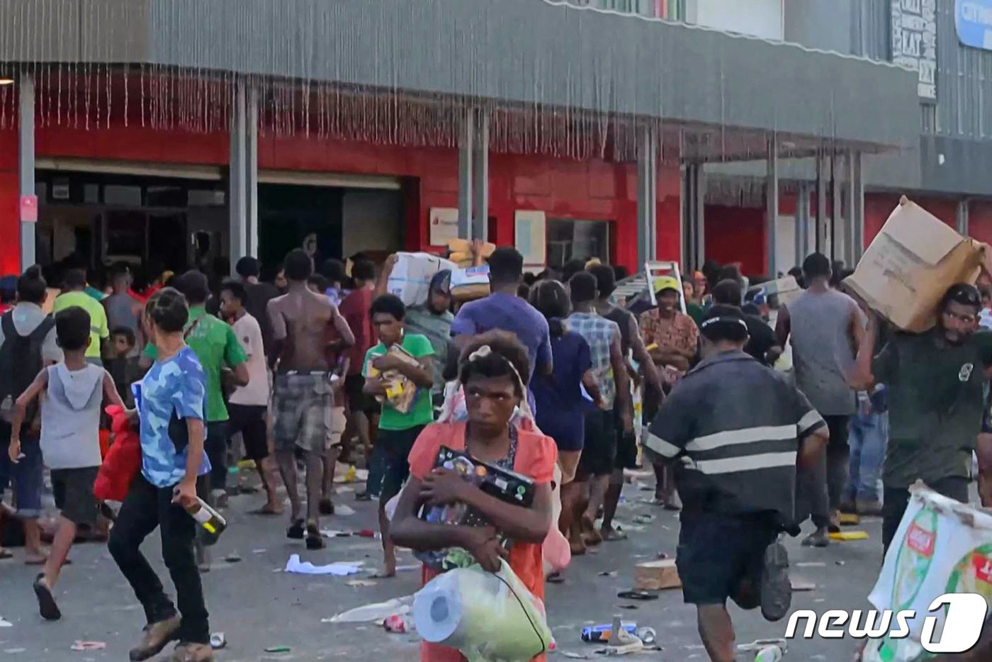(포트모르즈비 AFP=뉴스1) 정지윤 기자 = 10일(현지시간) 파푸아뉴기니의 수도 포트모르즈비에서 소요가 일어나 사람들이 가게에서 물건을 약탈하고 있다. 2024.01.10ⓒ A …