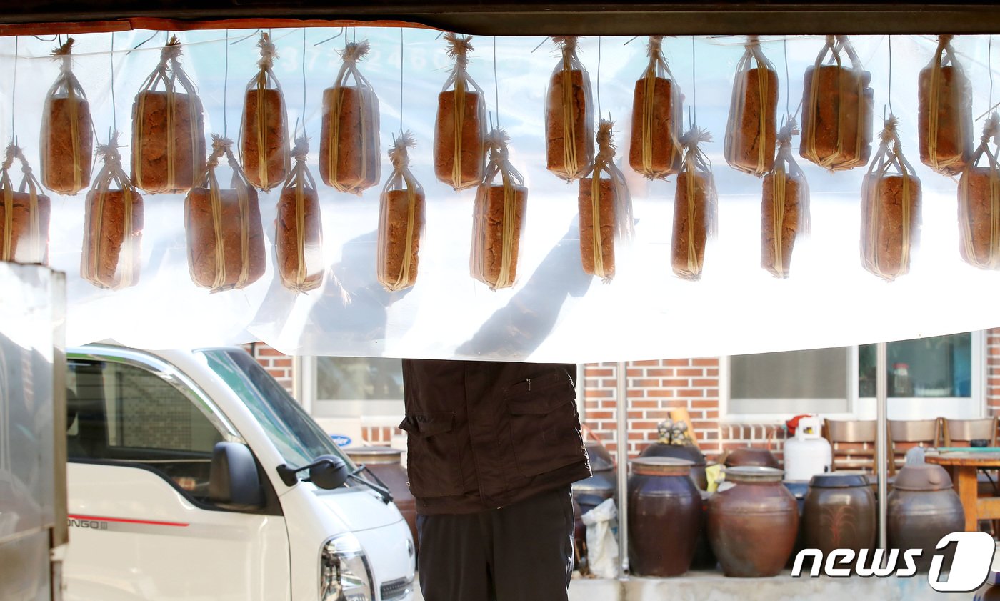 본문 이미지 - 11일 오후 경북 청도군 금천면 오일장이 열린 동곡시장에서 한 음식점 주인이 정월에 장을 담그기 위해 보온용 비닐로 덮어 매달아둔 메주를 살펴보고 있다. 2024.1.11/뉴스1 ⓒ News1 공정식 기자