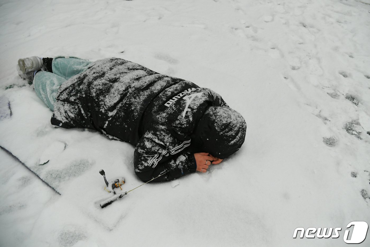 함박눈이 내린 1월14일 2024 화천산천어축제장을 찾은 한 어린이가 화천천 현장낚시터에서 얼음구멍에 얼굴을 숙인 채 산천어를 찾고 있다.&#40;화천군 제공&#41; 2024.1.14/뉴스1 ⓒ News1 한귀섭 기자