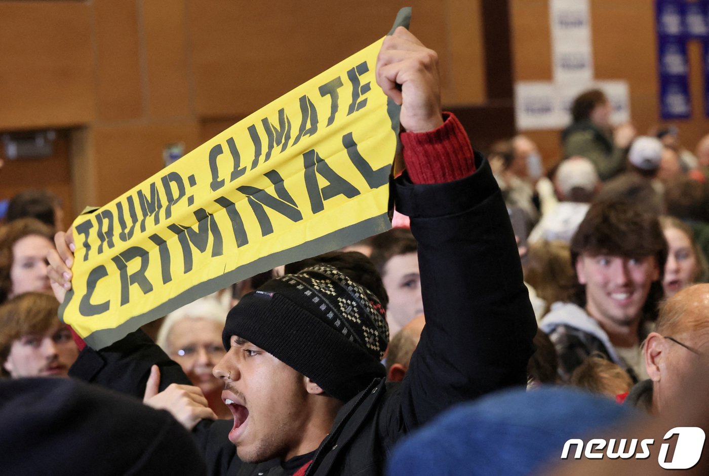본문 이미지 - 14일(현지시간) 미국 공화당 아이오카 코커스에서 한 기후 활동가가 "트럼프는 기후 범죄자＂라는 팻말을 들고 반트럼프 시위를 벌이고 있다. ⓒ 로이터=뉴스1 ⓒ News1 박형기 기자