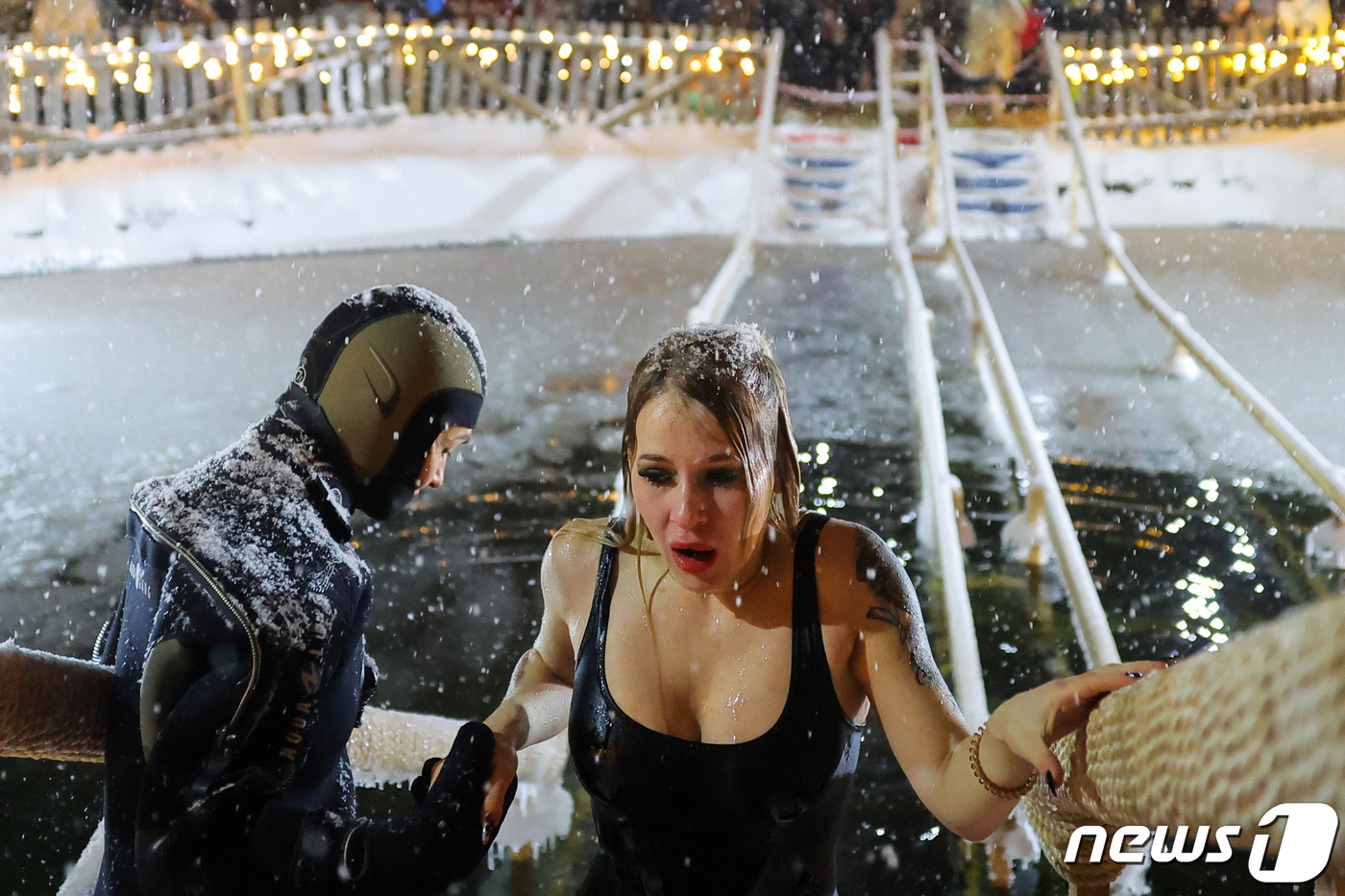(모스크바 로이터=뉴스1) 최종일 기자 = 18일(현지시간) 러시아 모스크바에서 러시아 정교회의 주현절 기념 목욕 축제가 열린 가운데 한 여성이 파랗게 질린 표정으로 얼음물에서 나 …
