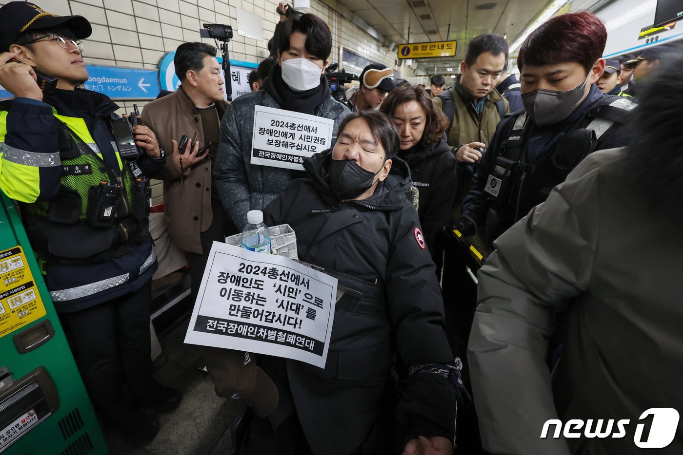 본문 이미지 - 박경석 전국장애인차별철폐연대(전장연) 대표를 비롯한 전장연 관계자들이 2일 오전 서울 종로구 4호선 혜화역 승강장에서 열린 출근길 지하철 탑승 시위에서 지하철 탑승을 시도하고 있다. 2024.1.2/뉴스1 ⓒ News1 민경석 기자