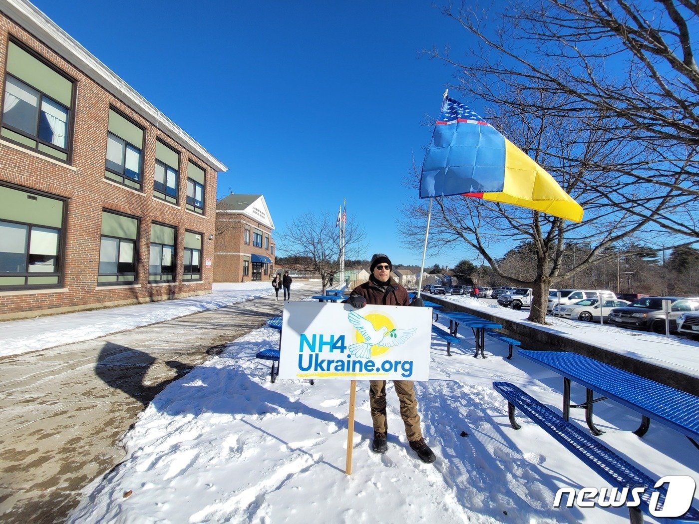 본문 이미지 - 미국 공화당 대선후보 경선에 출마한 니키 헤일리 전 유엔대사가 21일(현지시간) 뉴햄프셔 데리의 길버트 후드 중학교에서 유세를 개최한 가운데, 민주당원인 브라이언 놀란이 우크라이나를 지지하는 깃발을 들고 헤일리 전 대사를 지원하고 있다. 2024.01.21.