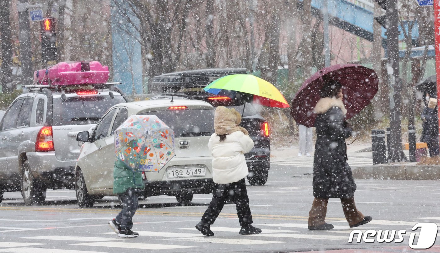 광주와 전남 7개 시군&#40;나주·목포·영암·무안·함평·장성·영광&#41;에 대설주의보가 내려진 22일 오후 광주시 서구 상무지구에 한 가족이 눈을 피해 걷고 있다.2024.1.22/뉴스1 ⓒ News1 김태성 기자