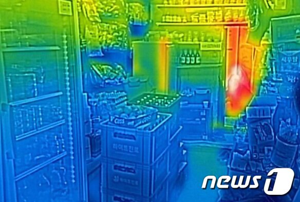 본문 이미지 - 서울 용산구 쪽방촌 내 슈퍼 한켠에서 어르신이 몸을 녹이고 있다. 열화상카메라는 온도가 높을수록 붉은색으로 나타나며 상대적으로 온도가 낮은 곳은 푸른색으로 나타난다. ⓒ 뉴스1 박지혜 기자
