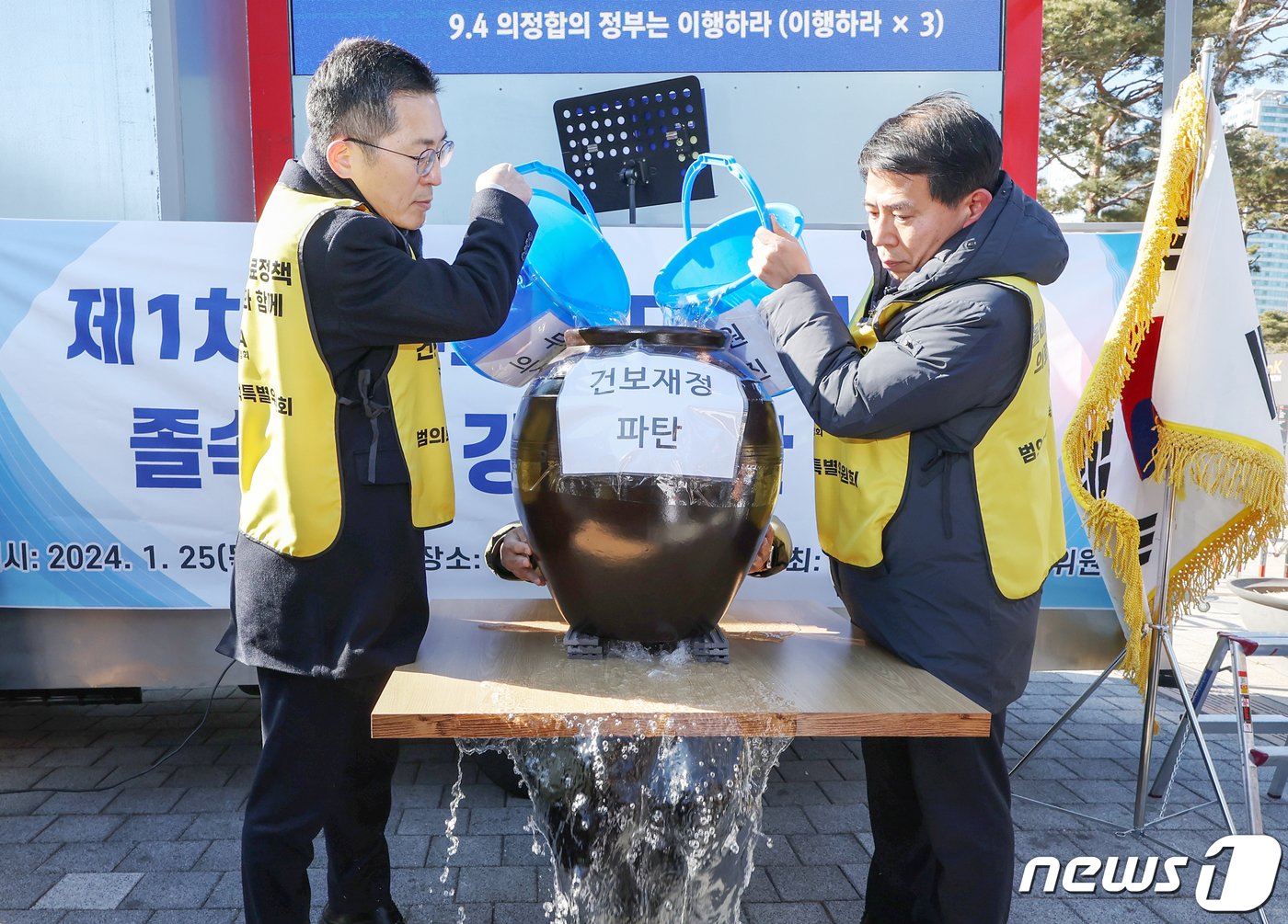 이필수 대한의사협회 회장&#40;왼쪽&#41;이 25일 오후 서울 용산구 전쟁기념관 앞에서 열린 &#39;제1차 정부의 의대정원 증원 졸속추진 강력 규탄 집회&#39;에서 의대 정원 확대로 인한 건보 재정 악화를 주장하며 &#39;밑 빠진 독에 물 붓기&#39; 퍼포먼스를 하고 있다. 2024.1.25/뉴스1 ⓒ News1 민경석 기자