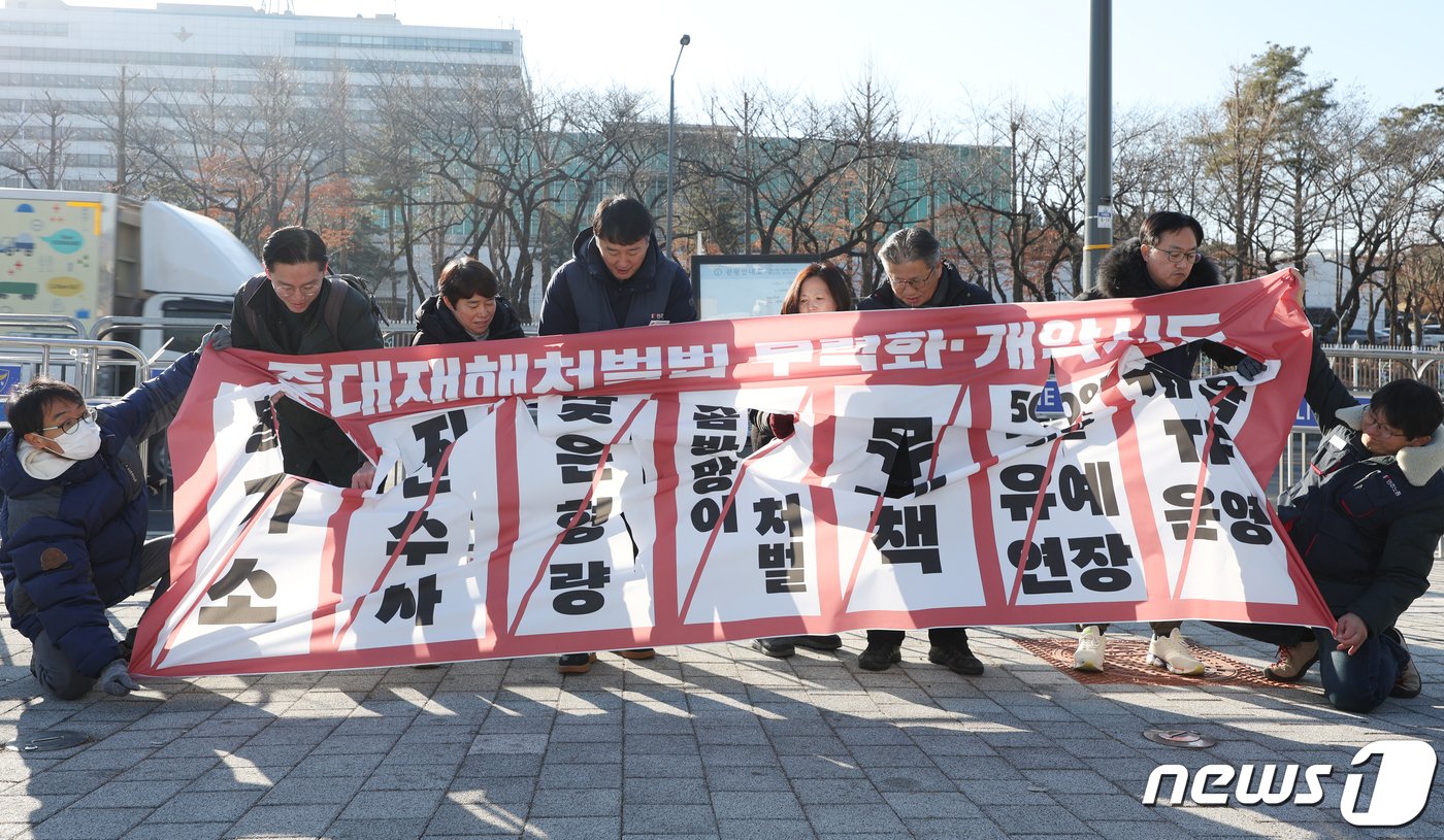 민주노총 관계자들이 26일 오전 서울 용산 전쟁기념관 앞에서 열린 중대재해처벌법 시행 2년 기자회견에서 중대재해처벌법 개악 시도 중단과 50인 미만 사업장의 적용을 촉구하는 현수막 찢기 퍼포먼스를 하고 있다. 2024.1.26/뉴스1 ⓒ News1 김민지 기자