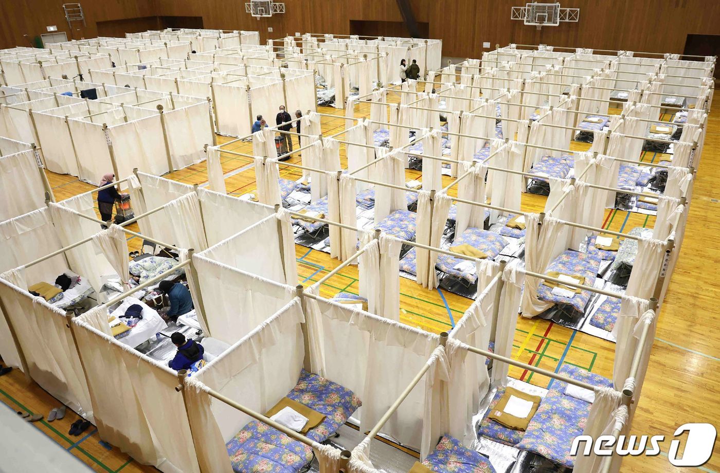 (가나자와 AFP=뉴스1) 권진영 기자 = 11일 일본 이시카와현 가나자와에 설치된 지진 피난소의 모습. 입소자별로 칸막이가 나뉘어져 있고 침구가 배부된 것을 확인할 수 있다. 2 …