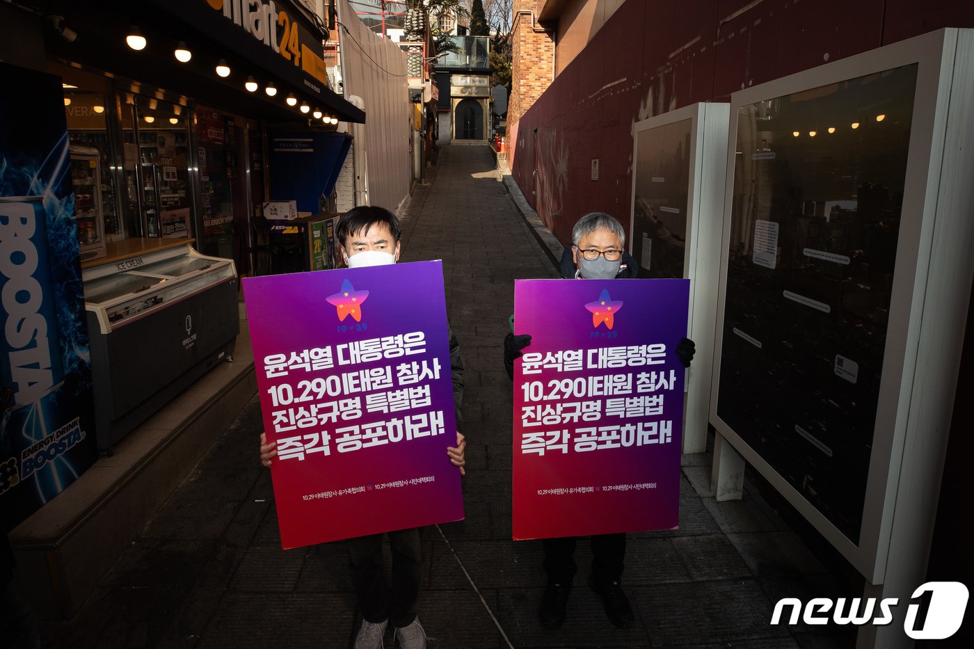 본문 이미지 - 29일 서울 이태원 참사 현장 앞에서 열린 이태원참사 특별법 공포를 촉구하는 기자회견에서 참석자들이 팻말을 들고 참사 현장에 서 있다. 2024.1.29/뉴스1 ⓒ News1 유승관 기자