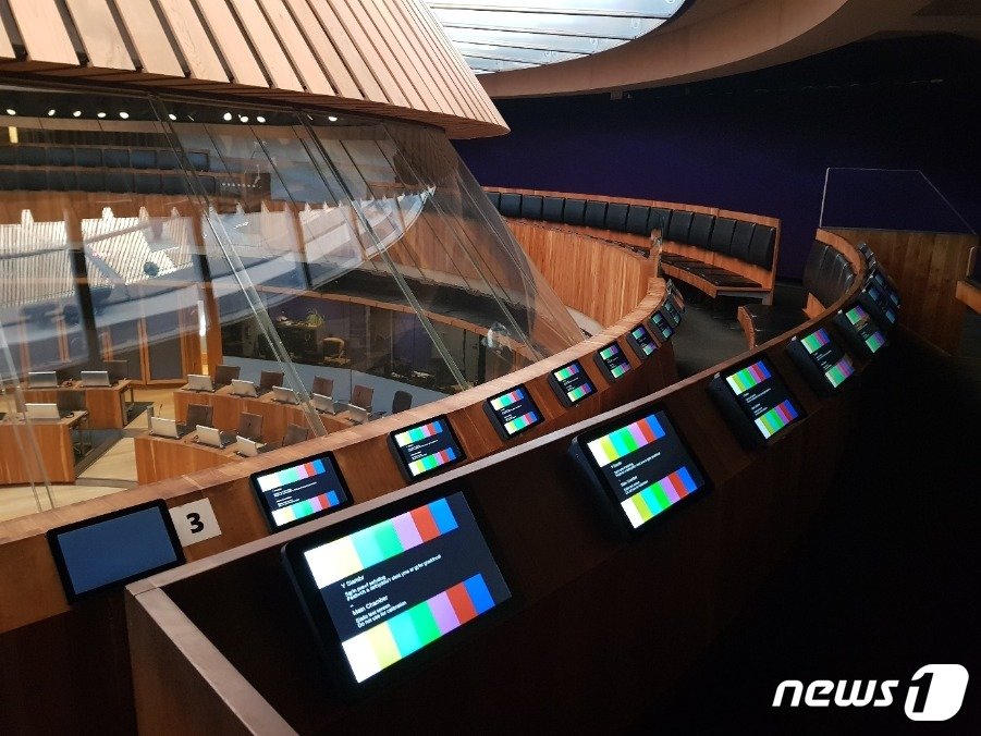 본문 이미지 - 영국 웨일스 의회 세네드&#40;Senedd&#41; 본회의장 위에 있는 방청객 좌석 전경. 영국에서 유일하게 이중언어를 사용하는 의회 건물인 만큼 좌석에도 동시통역 기능이 잘 갖춰져 있다. ⓒ News1 조아현 통신원