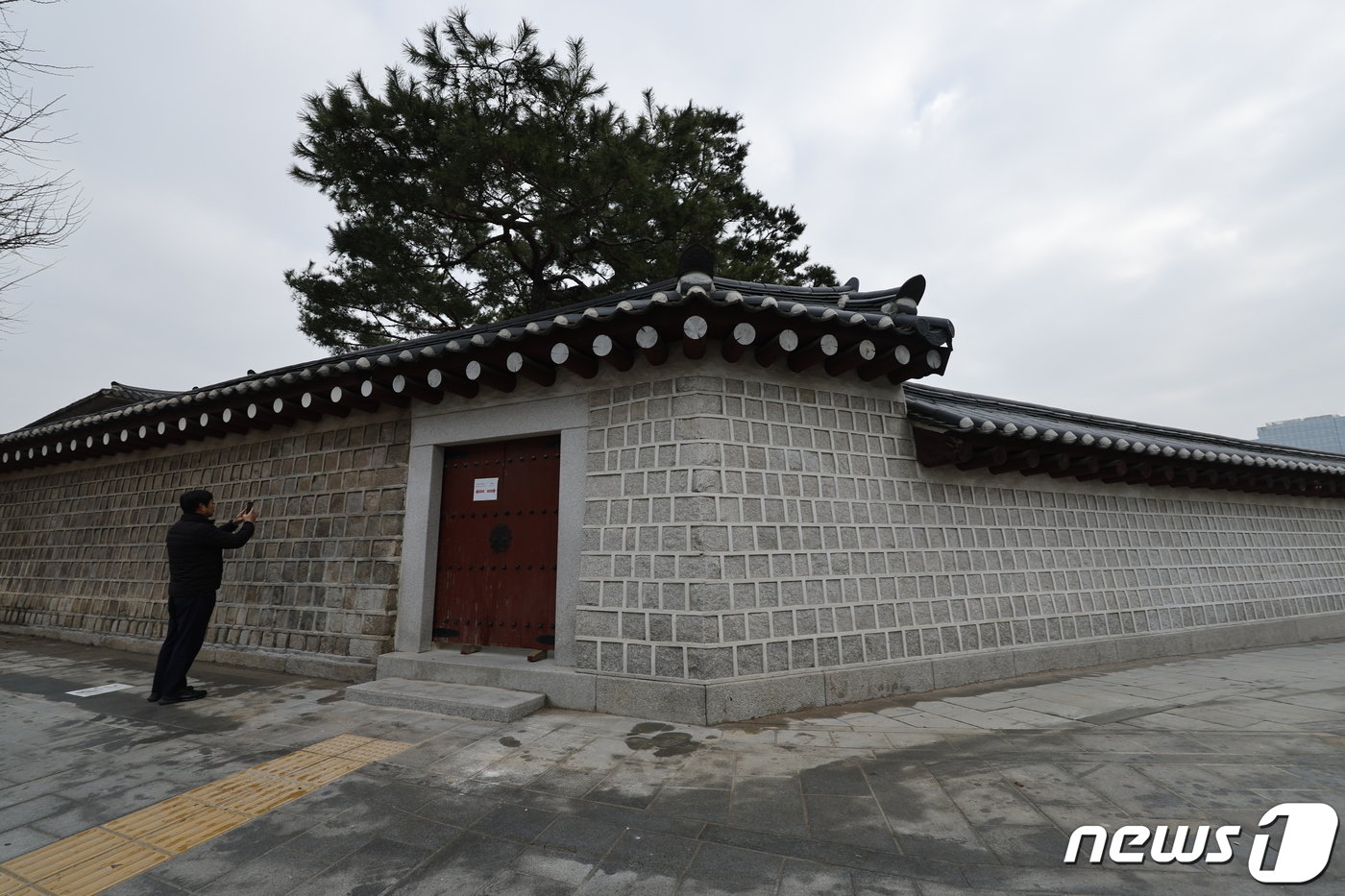 본문 이미지 - 4일 서울 종로구 경복궁에서 담장 낙서가 복원된 모습을 한 시민이 촬영하고 있다. 2024.1.4/뉴스1 ⓒ News1 안은나 기자