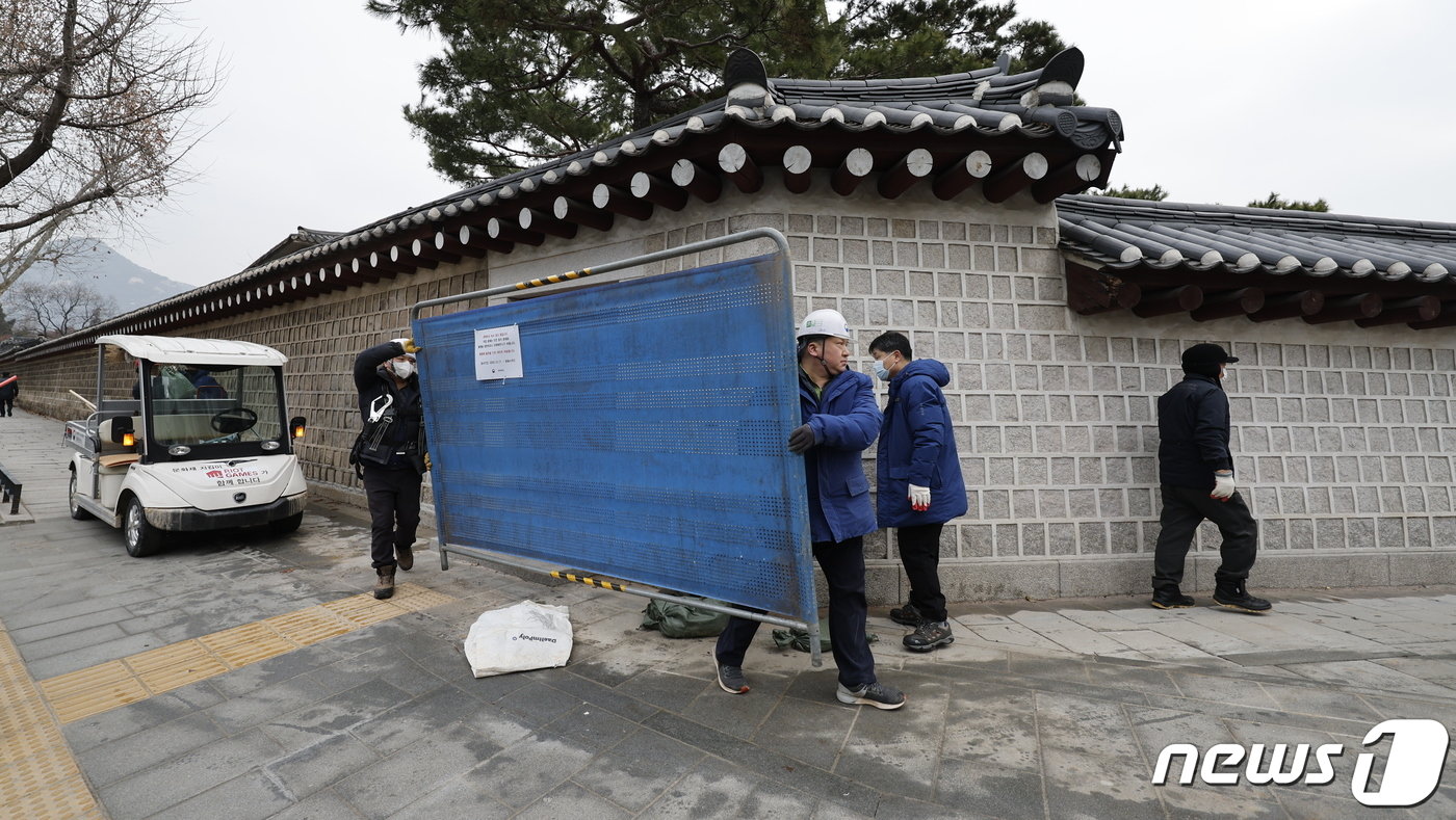 본문 이미지 - 4일 서울 종로구 경복궁 영추문에서 담장 낙서 제거 작업을 마친 문화재청 관계자들이 가림막을 철거하고 있다. 2024.1.4/뉴스1 ⓒ News1 안은나 기자