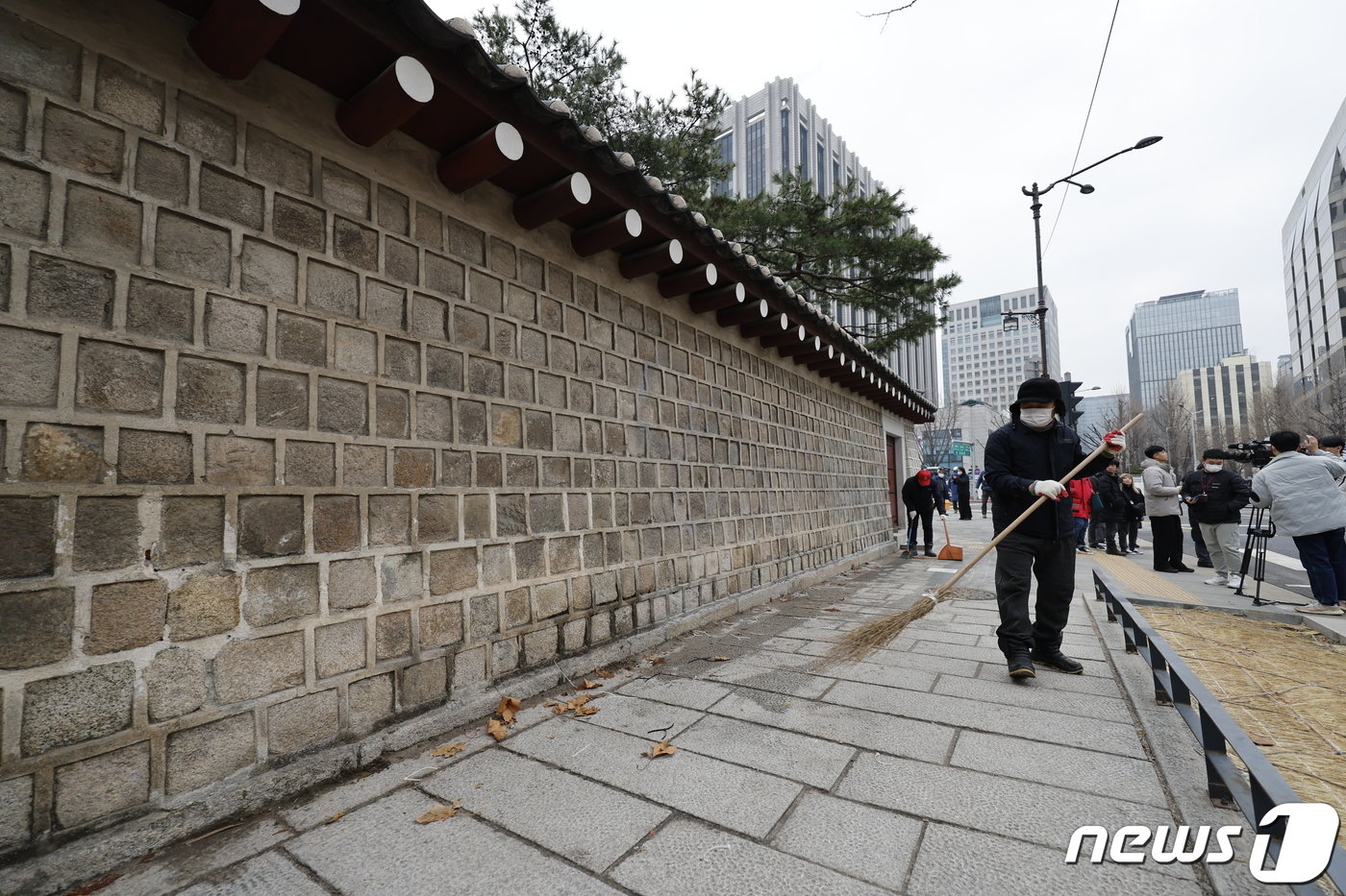 본문 이미지 - 4일 서울 종로구 경복궁에서 담장 낙서 제거 작업을 마친 문화재청 관계자들이 가림막을 철거한 뒤 청소하고 있다. 2024.1.4/뉴스1 ⓒ News1 안은나 기자