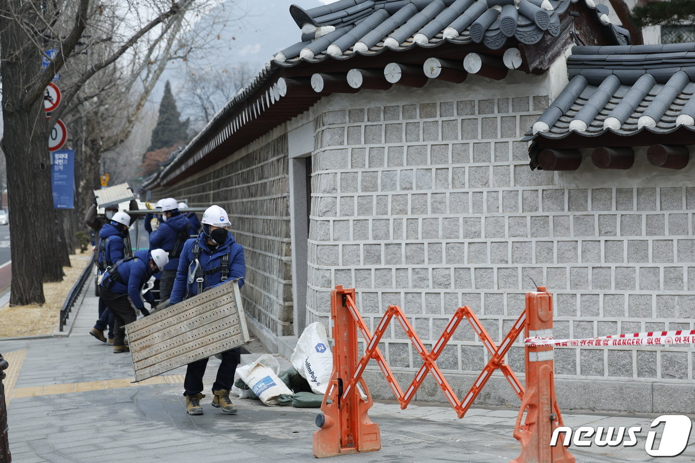 본문 이미지 - 4일 서울 종로구 경복궁에서 담장 낙서 제거 작업을 마친 문화재청 관계자들이 가림막을 철거하고 있다. 2024.1.4/뉴스1 ⓒ News1 안은나 기자