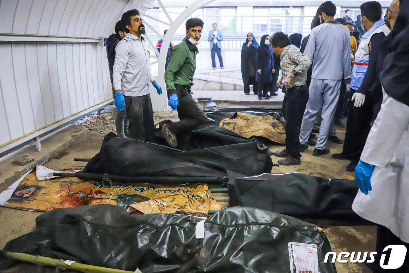 본문 이미지 - 3일 (현지시간) 이란 테헤란 남쪽 케르만에서 발생한 가셈 솔레이마니 전 이란 혁명 수비대 사령관 4주기 추모식 폭발의 희생자를 주민들이 수습을 하고 있다. 2024.1.4 ⓒ AFP=뉴스1 ⓒ News1 우동명 기자