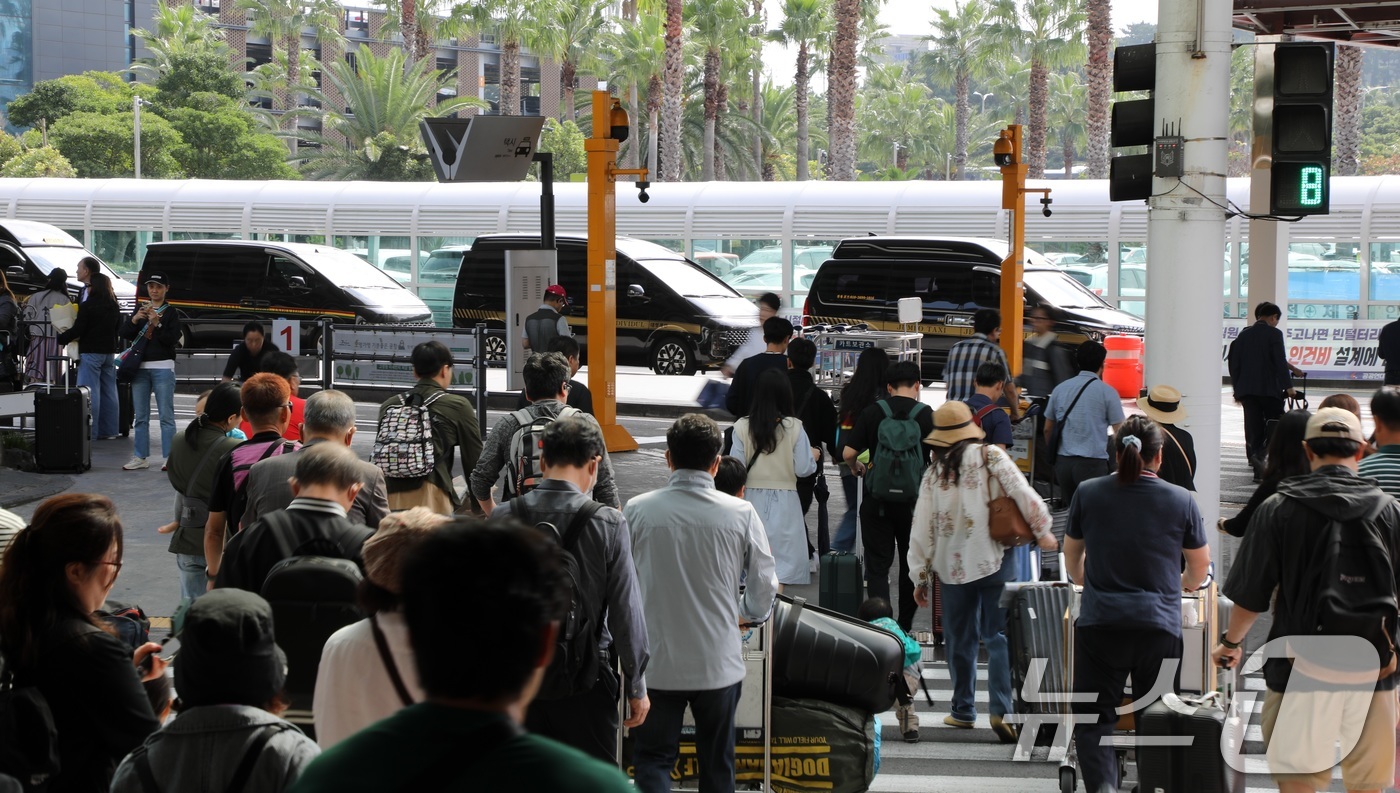 (제주=뉴스1) 고동명 기자 = 본격적인 징검다리 연휴가 시작된 1일 오전 제주국제공항에 도착한 관광객들이 길을 건너고 있다.제주관광협회는 지난 27일부터 10월6일까지 제주에 3 …