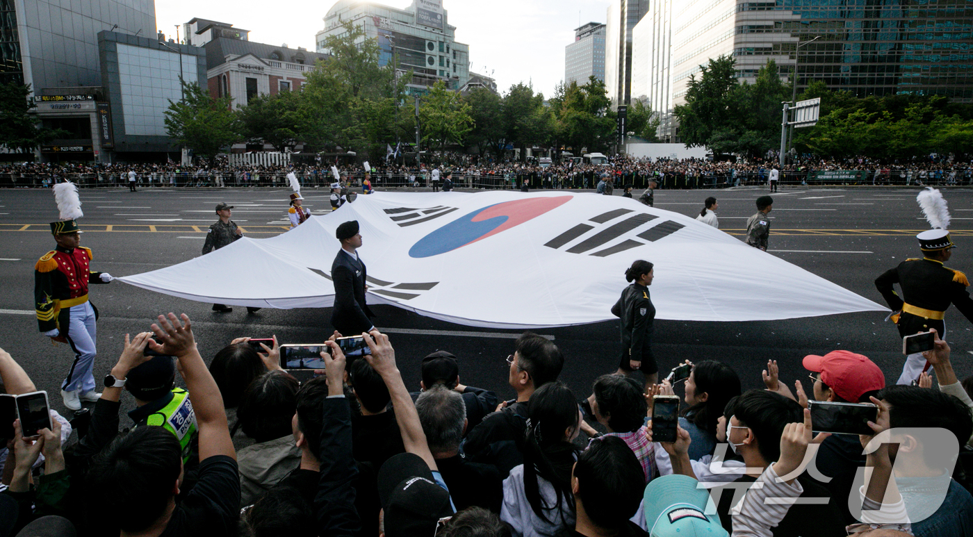 (서울=뉴스1) 이승배 기자 = 건군 제76주년 국군의 날인 1일 오후 서울 세종대로 일대에서 열린 시가행진에서 서울 수복을 기념하는 대형 태극기가 행진하고 있다.'강한 국군, 국 …