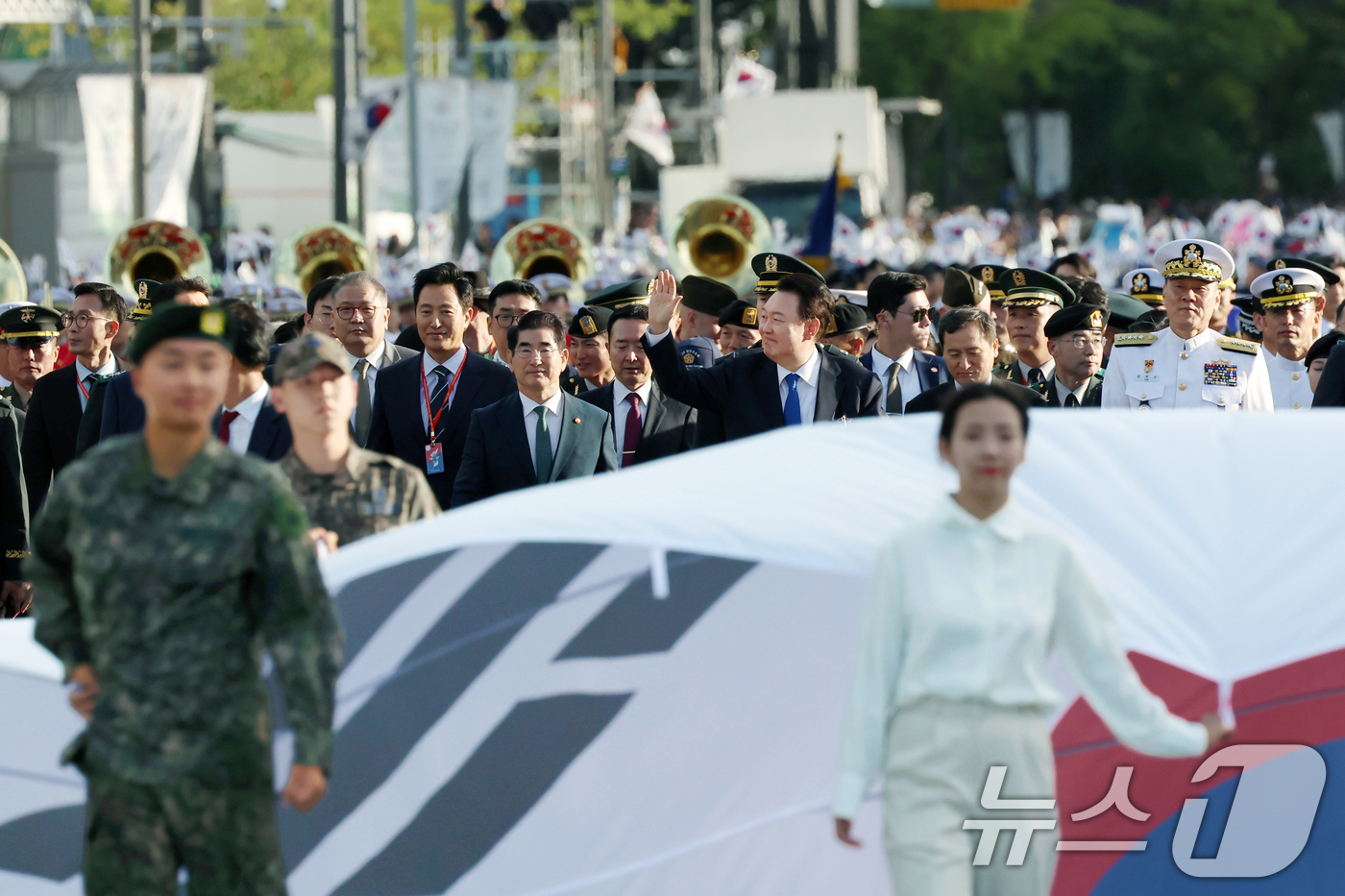 (서울=뉴스1) 송원영 기자 = 윤석열 대통령이 1일 서울 광화문 일대에서 열린 국군의날 시가행진에서 대형 태극기를 선두로 국민과 함께 광화문 월대를 향해 행진하며 인사하고 있다. …