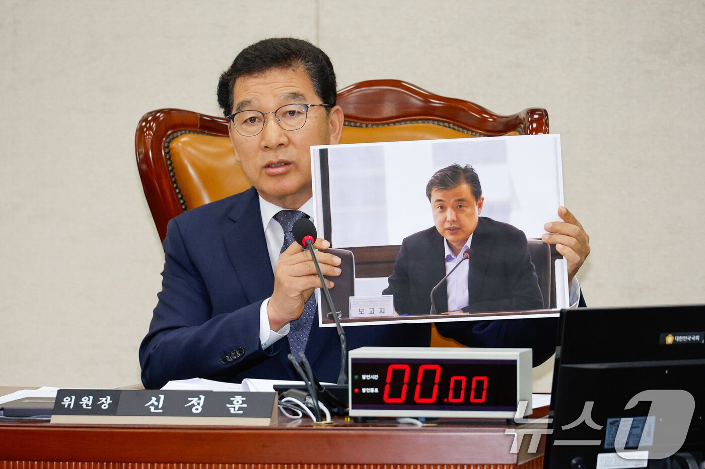 본문 이미지 - 신정훈 국회 행정안전위원회 위원장이 10일 오전 서울 여의도 국회 행안위에서 열린 중앙선거관리위원회·진실·화해를위한과거사정리위원회·소방청·한국소방산업기술원 국정감사에서 황인수 조사1국장의 언론보도 사진을 들고 마스크를 벗을 것을 요구하고 있다. 2024.10.10/뉴스1 ⓒ News1 안은나 기자