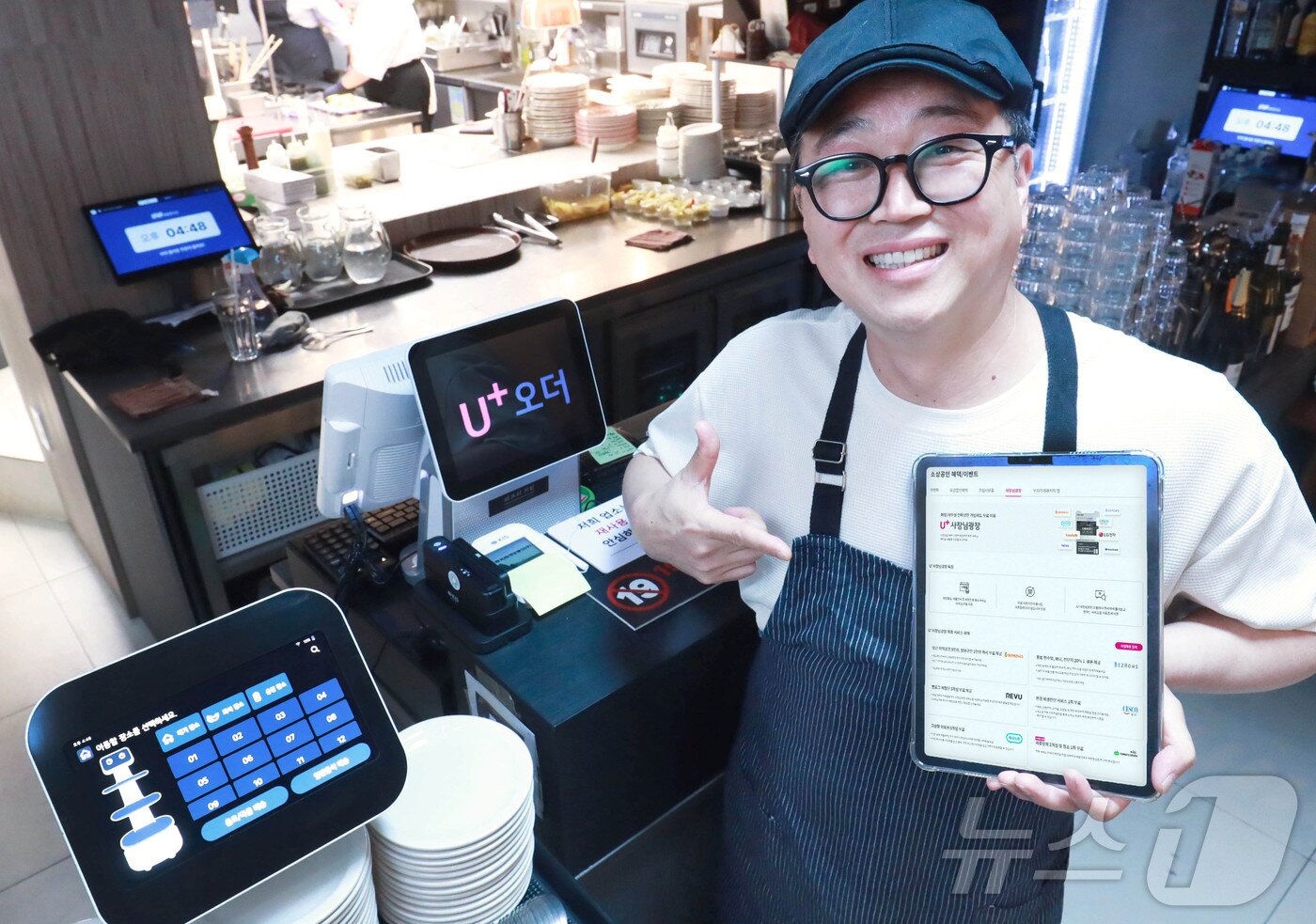 본문 이미지 - 지난 4월 LGU+ &#39;식당연구소&#39; 프로젝트로 문을 연 파브리키친 내부에서 관계자가 &#39;U+우리가게패키지&#39;를 설명하는 태블릿 화면을 들어 보이고 있다 &#40;LG유플러스 제공&#41;. 2024.10.10/뉴스1