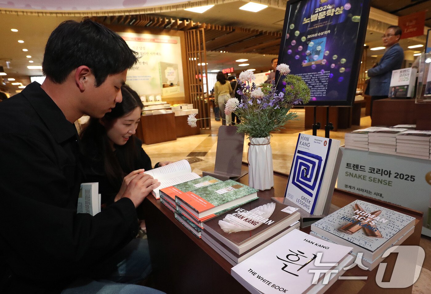 본문 이미지 - 10일 서울 종로구 교보문고에서 시민들이 노벨문학상을 수상한 작가 한강의 책을 살펴보고 있다.  2024.10.10/뉴스1 ⓒ News1 박세연 기자