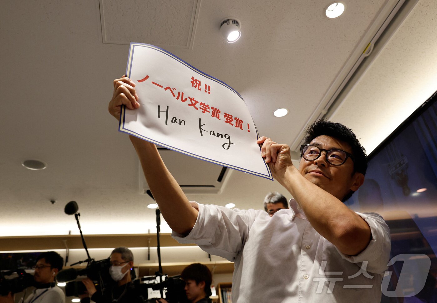 일본 도쿄 기노쿠니야 서점의 직원이 10일 &#39;노벨문학상 수상자 한강을 축하합니다&#39;라고 쓰인 종이를 들고 있다. 24.10.10 ⓒ 로이터=뉴스1 ⓒ News1 김예슬 기자