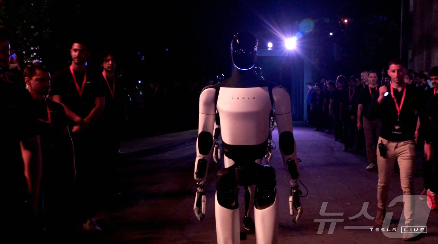 본문 이미지 - 테슬라가 개발한 옵티머스 로봇이 10일(현지시간) 캘리포니아주 로스앤젤레스에서 열린 테슬라 로보택시 공개 행사장을 누비고 있다. ⓒ 로이터=뉴스1 ⓒ News1 박형기 기자