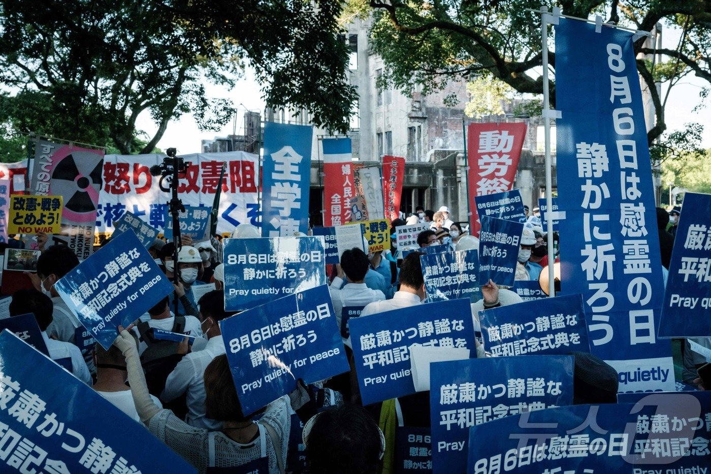 본문 이미지 - 일본 히로시마 원폭 돔 주변에서 피단협 활동가들이 "평화를 위해 조용히 기도하자＂는 내용의 플래카드를 들고 있다. 2021.08.06/ ⓒ AFP=뉴스1 ⓒ News1 권진영 기자