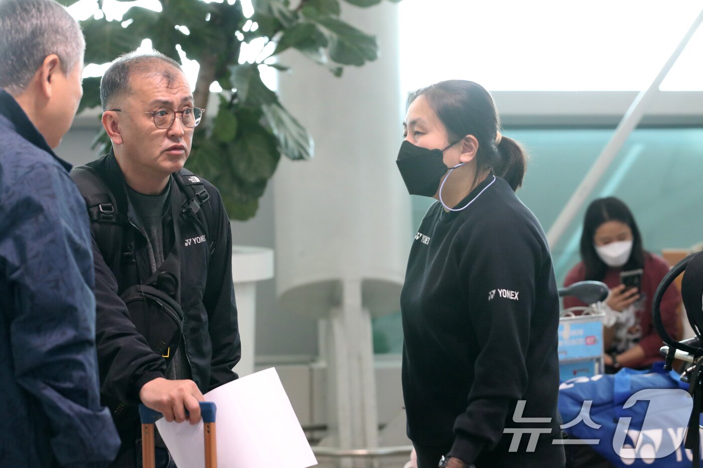 본문 이미지 - 김학균 대한민국 배드민턴 대표팀 감독이 13일 오전 덴마크 오픈 배드민턴 경기 참가를 위해 출국 전 관계자들과 대화하고 있다. 뒤에 스마트을 만지고 있는 안세영의 모습이 보인다. 2024.10.13/뉴스1 ⓒ News1 이승배 기자