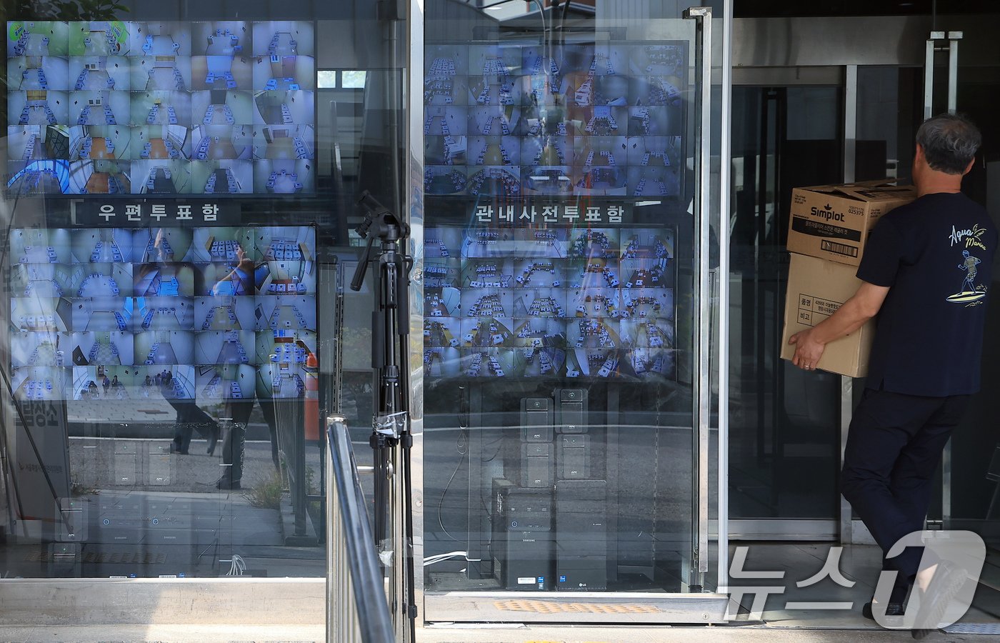 본문 이미지 - 서울특별시 교육감 보궐선거 사전투표 종료 다음날인 13일 오후 서울 종로구 창경궁로 서울시선거관리위원회 입구에 설치된 25개 구위원회 관내사전투표함 보관장소 CCTV 영상 열람용 모니터 옆으로 시민이 지나고 있다. 2024.10.13/뉴스1 ⓒ News1 박정호 기자