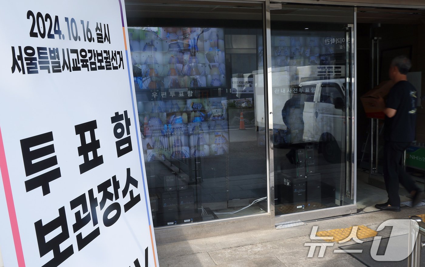 본문 이미지 - 서울특별시 교육감 보궐선거 사전투표 종료 다음날인 13일 오후 서울 종로구 창경궁로 서울시선거관리위원회 입구에 설치된 25개 구위원회 관내사전투표함 보관장소 CCTV 영상 열람용 모니터 옆으로 시민이 지나고 있다. 2024.10.13/뉴스1 ⓒ News1 박정호 기자