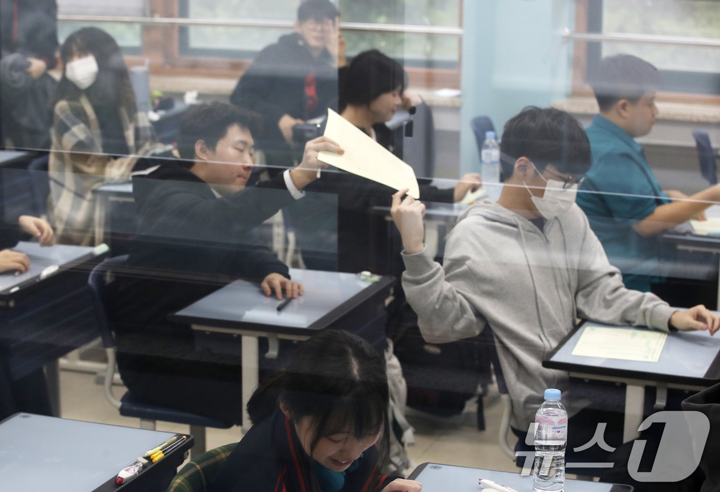 본문 이미지 - 2025학년도 대학수학능력시험을 30일 앞두고 10월 전국연합학력평가가 일제히 실시된 15일 오전 서울 관악구 당곡고등학교에서 고3 수험생들이 1교시 문제지를 나누고 있다. 10월 전국연합학력평가는 수능시험 전 마지막 모의고사로, 고등학교 전 학년을 대상으로 전 영역, 전 범위에서 출제된다. 2024.10.15/뉴스1 ⓒ News1 오대일 기자