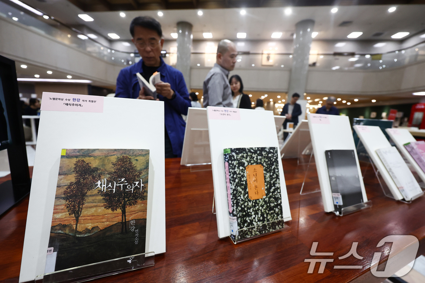 (서울=뉴스1) 김민지 기자 = 15일 서울 여의도 국회도서관 중앙홀에 마련된 '한강 작가 노벨문학상 수상 특별전'을 찾은 시민들이 책을 살펴보고 있다.특별전은 이날부터 약 2개월 …