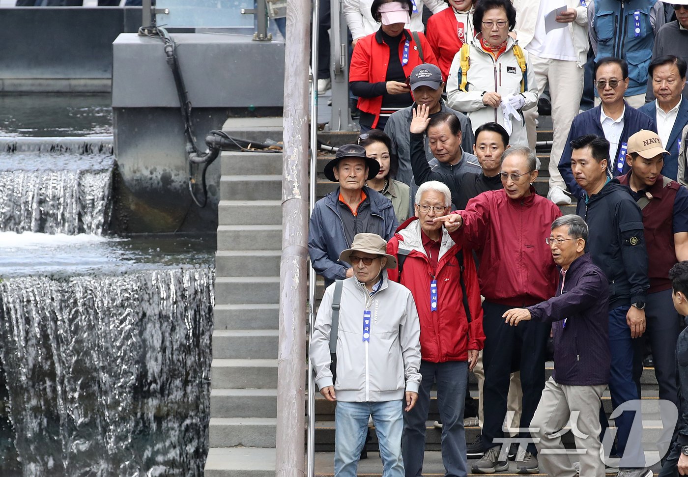 본문 이미지 - 이명박 전 대통령이 16일 오전 서울 중구 청계천을 찾아 자신의 서울시장 재임 당시 현재 모습으로 복원한 산책로를 걸으며 참석자들과 대화하고 있다. '청계천을 사랑하는 모임'(청사모)이 주관한 이날 행사에는 이명박 정부 인사들과 청계천 복원 관계자, 청계천 상인 대표 등 약 100여 명이 참여해 청계광장부터 성동 신답철교까지 약 5.8km를 함께 걸었다. 2024.10.16/뉴스1 ⓒ News1 오대일 기자