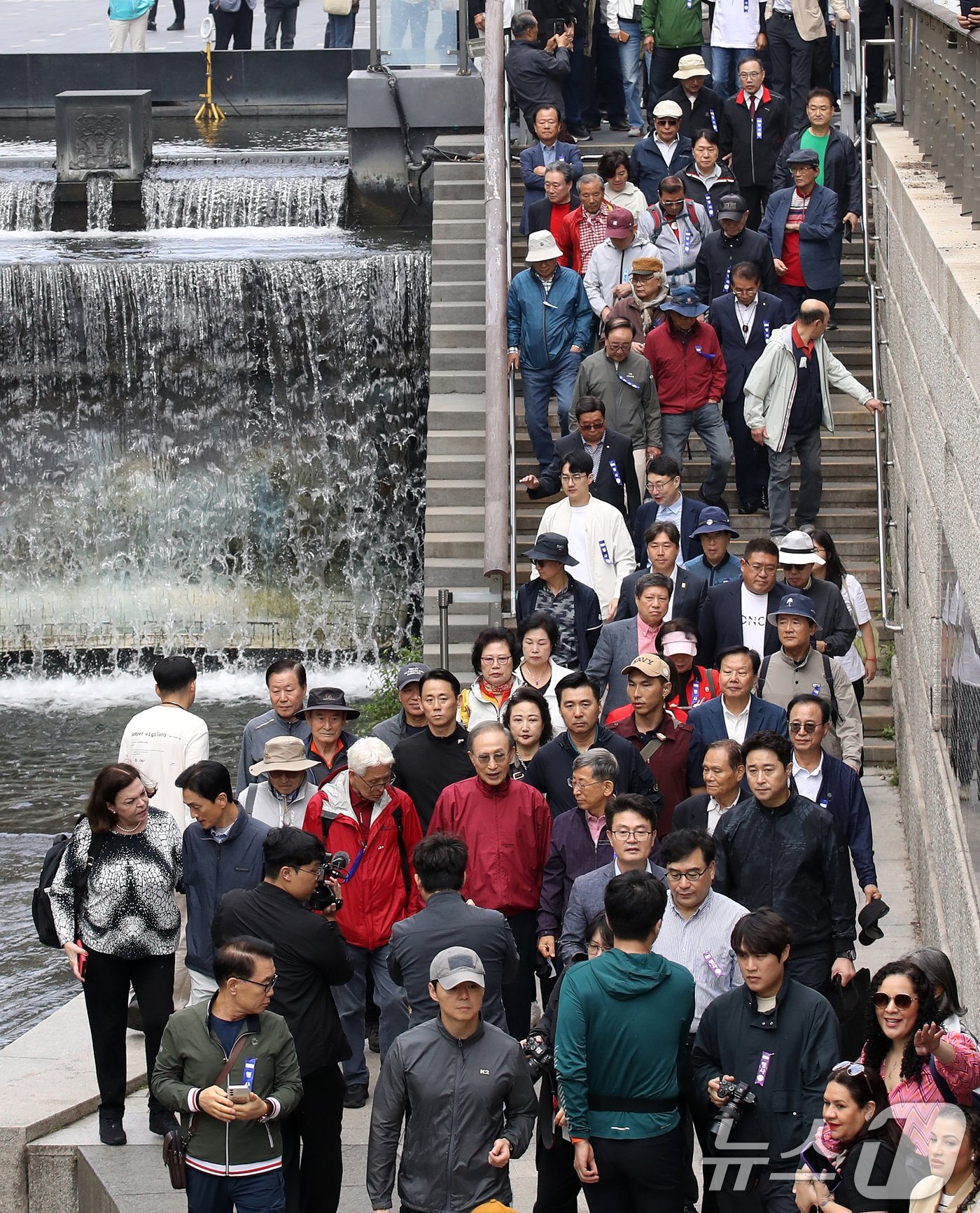 본문 이미지 - 이명박 전 대통령이 16일 오전 서울 중구 청계천을 찾아 자신의 서울시장 재임 당시 현재 모습으로 복원한 산책로를 걸으며 참석자들과 대화하고 있다. '청계천을 사랑하는 모임'(청사모)이 주관한 이날 행사에는 이명박 정부 인사들과 청계천 복원 관계자, 청계천 상인 대표 등 약 100여 명이 참여해 청계광장부터 성동 신답철교까지 약 5.8km를 함께 걸었다. 2024.10.16/뉴스1 ⓒ News1 오대일 기자