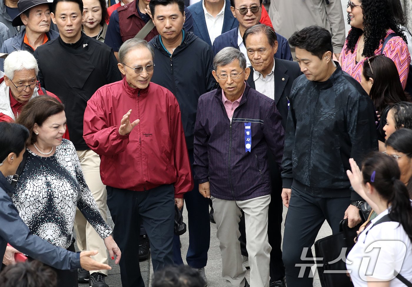 본문 이미지 - 이명박 전 대통령이 16일 오전 서울 중구 청계천을 찾아 자신의 서울시장 재임 당시 현재 모습으로 복원한 산책로를 걸으며 외국인 관광객들과 인사하고 있다. '청계천을 사랑하는 모임'(청사모)이 주관한 이날 행사에는 이명박 정부 인사들과 청계천 복원 관계자, 청계천 상인 대표 등 약 100여 명이 참여해 청계광장부터 성동 신답철교까지 약 5.8km를 함께 걸었다. 2024.10.16/뉴스1 ⓒ News1 오대일 기자