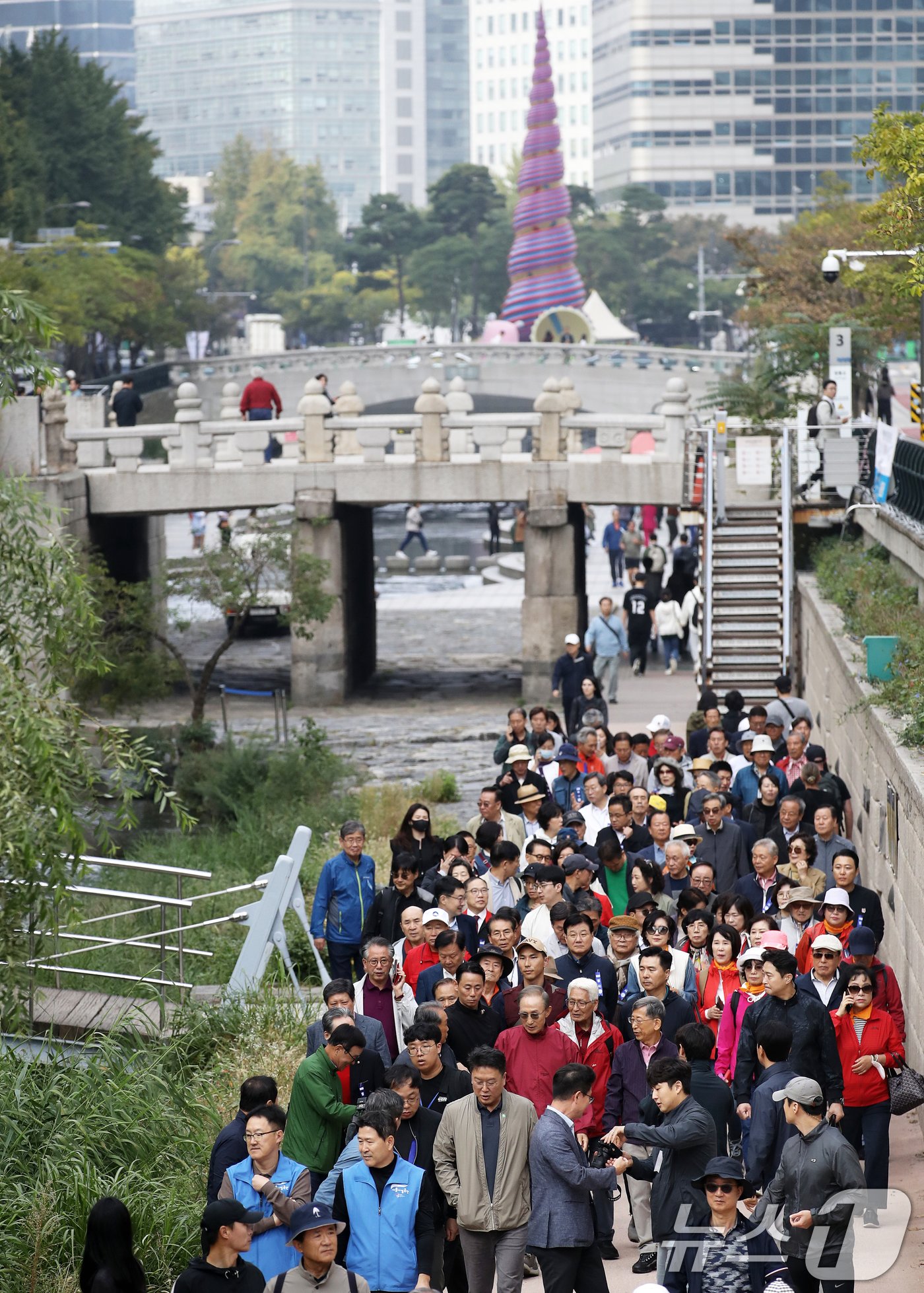 본문 이미지 - 이명박 전 대통령이 16일 오전 서울 중구 청계천을 찾아 자신의 서울시장 재임 당시 현재 모습으로 복원한 산책로를 걸으며 참석자들과 대화하고 있다. '청계천을 사랑하는 모임'(청사모)이 주관한 이날 행사에는 이명박 정부 인사들과 청계천 복원 관계자, 청계천 상인 대표 등 약 100여 명이 참여해 청계광장부터 성동 신답철교까지 약 5.8km를 함께 걸었다. 2024.10.16/뉴스1 ⓒ News1 오대일 기자