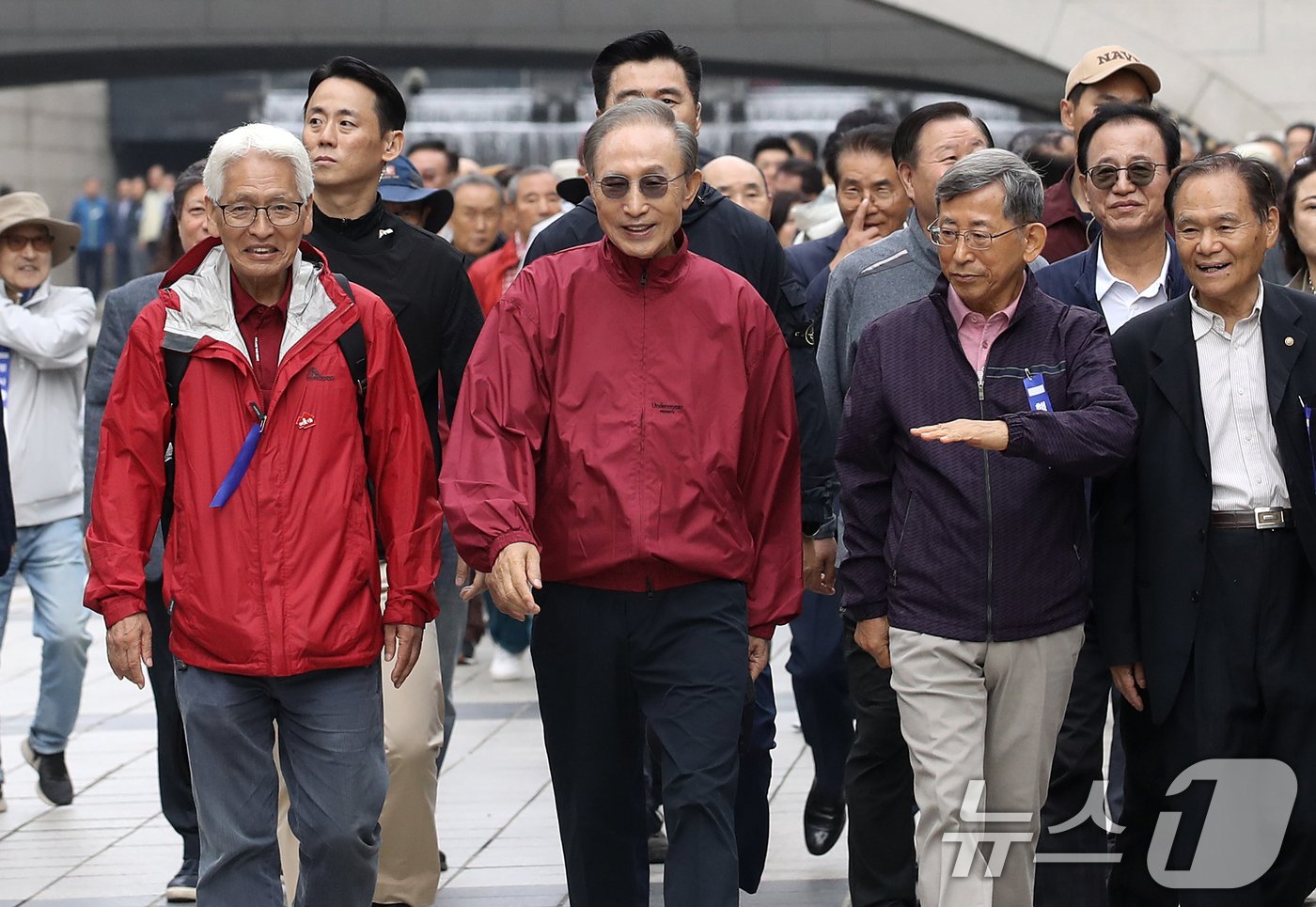 본문 이미지 - 이명박 전 대통령이 16일 오전 서울 중구 청계천을 찾아 자신의 서울시장 재임 당시 현재 모습으로 복원한 산책로를 걸으며 환하게 웃음짓고 있다. '청계천을 사랑하는 모임'(청사모)이 주관한 이날 행사에는 이명박 정부 인사들과 청계천 복원 관계자, 청계천 상인 대표 등 약 100여 명이 참여해 청계광장부터 성동 신답철교까지 약 5.8km를 함께 걸었다. 2024.10.16/뉴스1 ⓒ News1 오대일 기자