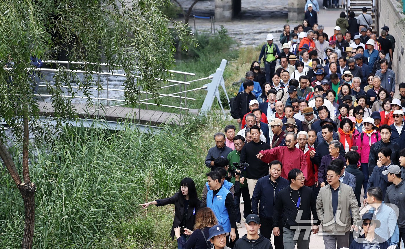 본문 이미지 - 이명박 전 대통령이 16일 오전 서울 중구 청계천을 찾아 자신의 서울시장 재임 당시 현재 모습으로 복원한 산책로를 걸으며 참석자들과 대화하고 있다. '청계천을 사랑하는 모임'(청사모)이 주관한 이날 행사에는 이명박 정부 인사들과 청계천 복원 관계자, 청계천 상인 대표 등 약 100여 명이 참여해 청계광장부터 성동 신답철교까지 약 5.8km를 함께 걸었다. 2024.10.16/뉴스1 ⓒ News1 오대일 기자