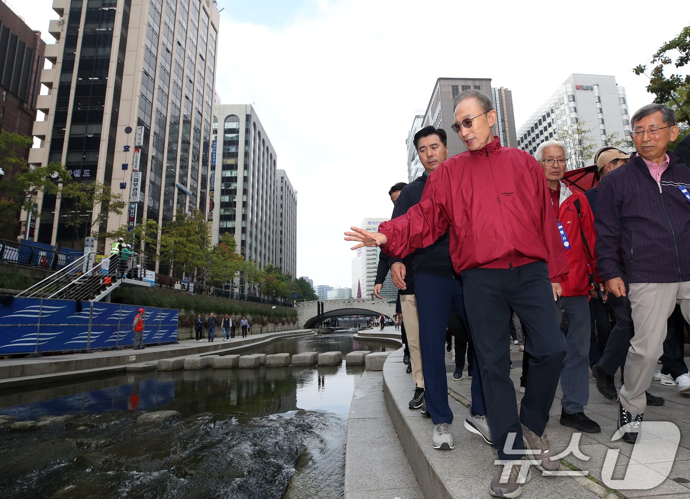 본문 이미지 - 이명박 전 대통령이 16일 오전 서울 중구 청계천을 찾아 자신의 서울시장 재임 당시 현재 모습으로 복원한 산책로를 걸으며 참석자들과 대화하고 있다. '청계천을 사랑하는 모임'(청사모)이 주관한 이날 행사에는 이명박 정부 인사들과 청계천 복원 관계자, 청계천 상인 대표 등 약 100여 명이 참여해 청계광장부터 성동 신답철교까지 약 5.8km를 함께 걸었다. 2024.10.16/뉴스1 ⓒ News1 오대일 기자