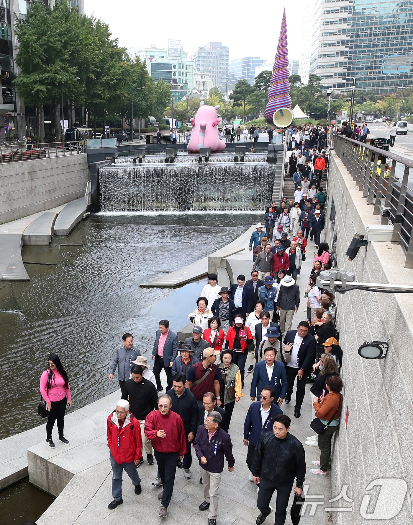 이명박 전 대통령이 16일 오전 서울 중구 청계천을 찾아 자신의 서울시장 재임 당시 현재 모습으로 복원한 산책로를 걸으며 참석자들과 대화하고 있다. &#39;청계천을 사랑하는 모임&#39;&#40;청사모&#41;이 주관한 이날 행사에는 이명박 정부 인사들과 청계천 복원 관계자, 청계천 상인 대표 등 약 100여 명이 참여해 청계광장부터 성동 신답철교까지 약 5.8km를 함께 걸었다. 2024.10.16/뉴스1 ⓒ News1 오대일 기자