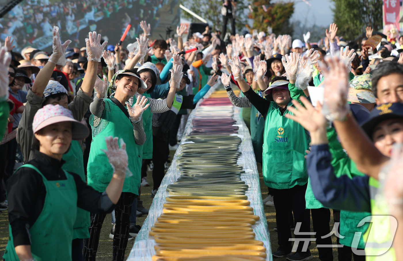 (이천=뉴스1) 김영운 기자 = ‘제23회 이천쌀문화축제’가 개막한 16일 오후 경기 이천시 모가면 이천농업테마공원에서 행사 관계자들이 600m 가래떡을 만들고 기념촬영을 하고 있 …