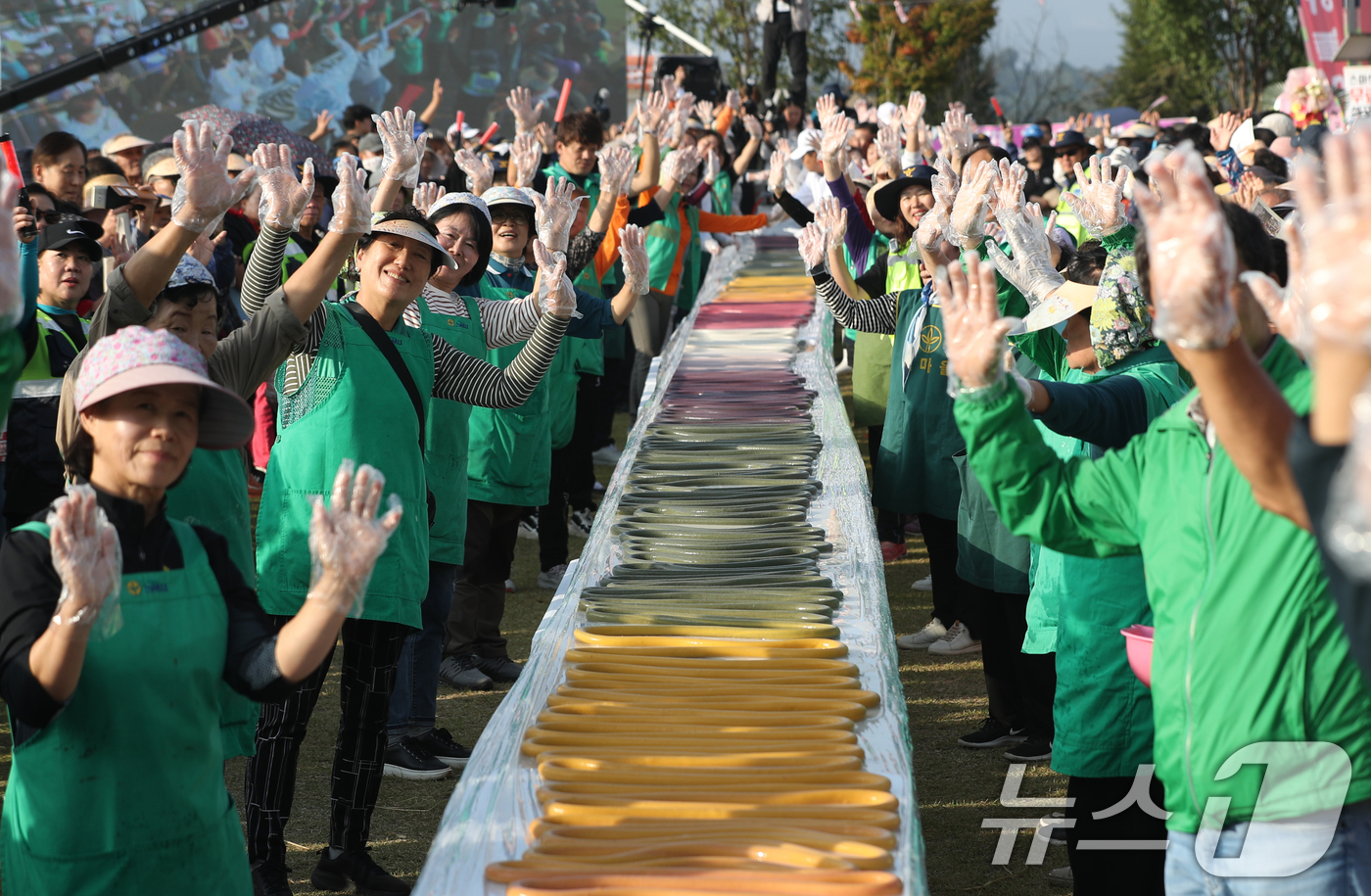 (이천=뉴스1) 김영운 기자 = ‘제23회 이천쌀문화축제’가 개막한 16일 오후 경기 이천시 모가면 이천농업테마공원에서 행사 관계자들이 600m 가래떡을 만들고 기념촬영을 하고 있 …