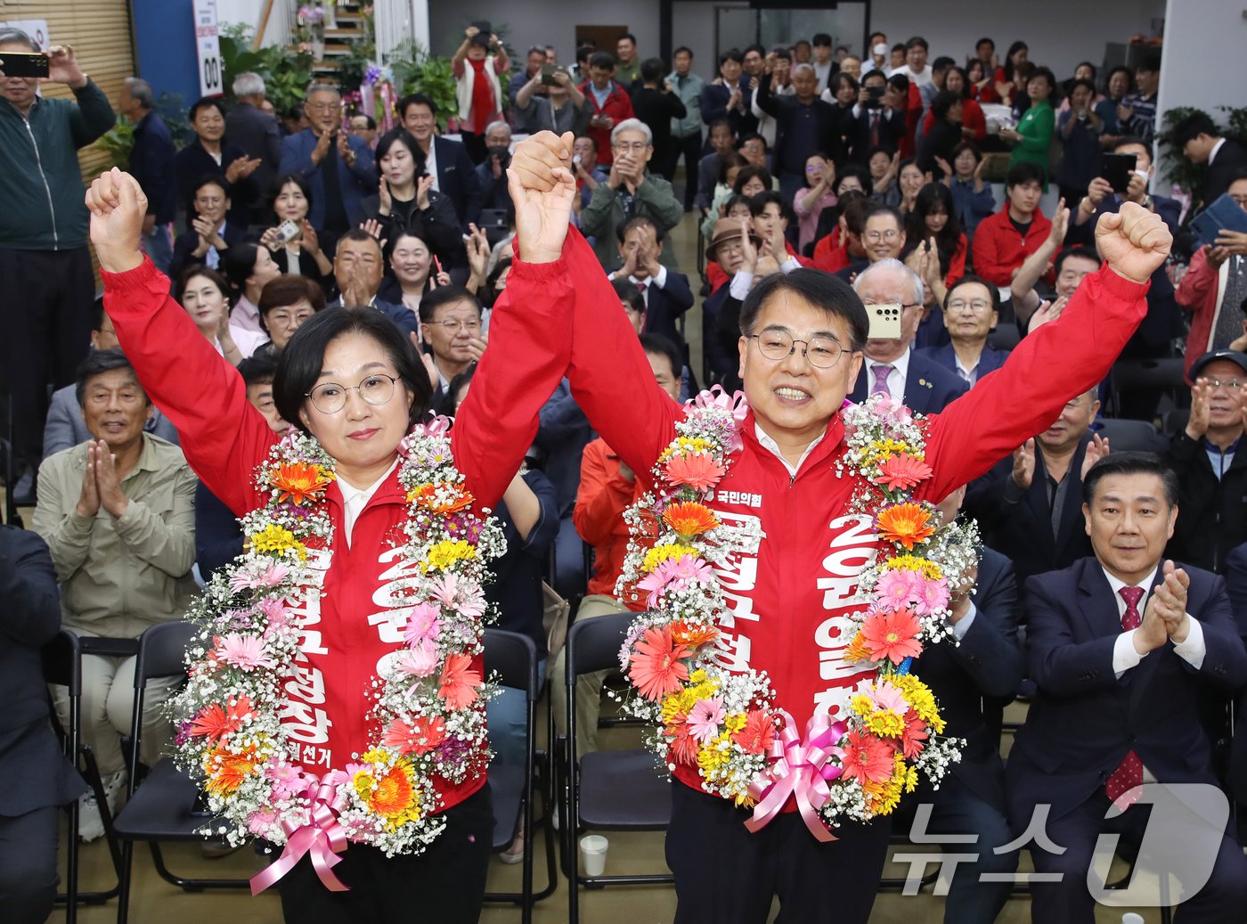 윤일현 국민의힘 금정구청장 보궐선거 후보가 16일 오후 부산 금정구 자신의 선거사무소에서 당선이 유력하게 되자 부인과 함께 꽃목걸이를 목에 걸고 환호하고 있다. 2024.10.16/뉴스1 ⓒ News1 윤일지 기자