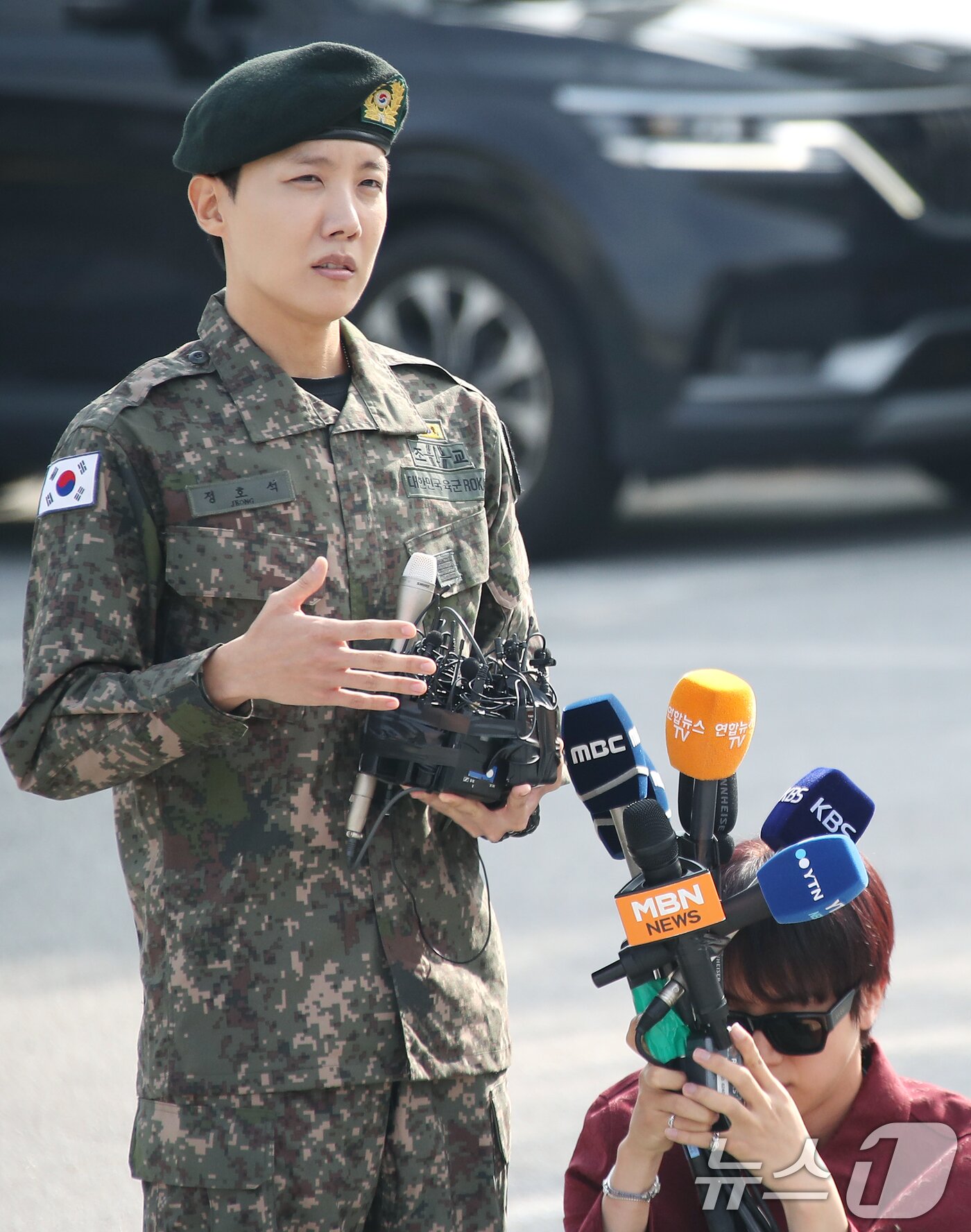 본문 이미지 - 방탄소년단&#40;BTS&#41; 진&#40;오른쪽&#41;이 17일 강원도 원주시에 위치한 육군 제36보병사단 백호 신병교육대에서 전역 인사를 하는 제이홉의 인터뷰를 위해 마이크를 들어주고 있다. 2024.10.17./뉴스1 ⓒ News1 권현진 기자