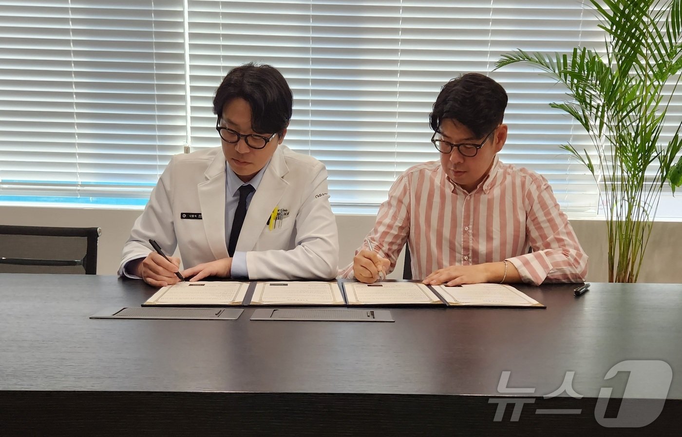 본문 이미지 - 나응식 그레이스 고양이병원 대표원장(왼쪽)과 강두한 더셈펫바이오 대표가 협약서에 서명하고 있다. ⓒ 뉴스1 한송아 기자