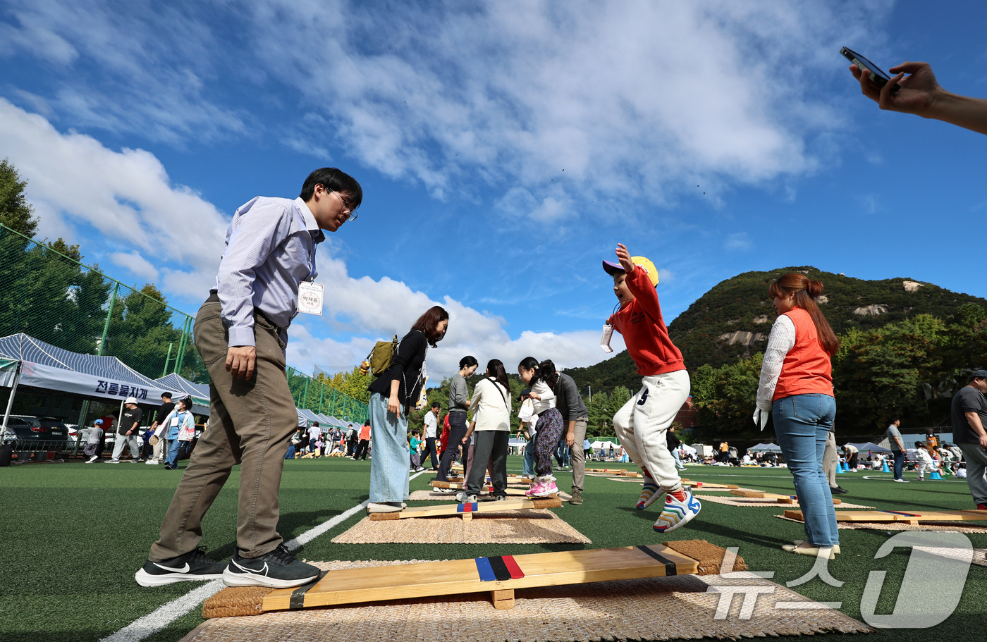 (서울=뉴스1) 구윤성 기자 = 주말인 19일 오전 서울 종로구 경복고등학교에서 열린 유치원 연합행사 '얘들아, 놀자! 민속놀이 한마당'에서 어린이들이 가족과 함께 널뛰기 체험을 …