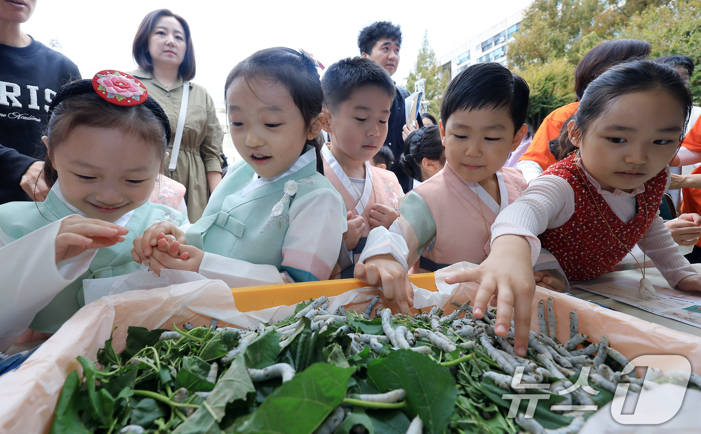 (서울=뉴스1) 박정호 기자 = 19일 서울 서초구 잠원로 잠원체육공원에서 열린 2024년 제10회 이웃과 함께하는 행복 한마당 잠원나루축제를 찾은 어린이들이 누에에게 뽕잎을 주고 …