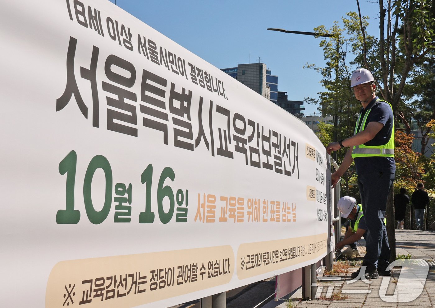 서울시선관위 관계자들이 2일 오전 서울시 종로구 서울시교육청 앞에 서울교육감보궐선거 홍보 현수막을 설치하고 있다.  2024.10.2/뉴스1 ⓒ News1 장수영 기자